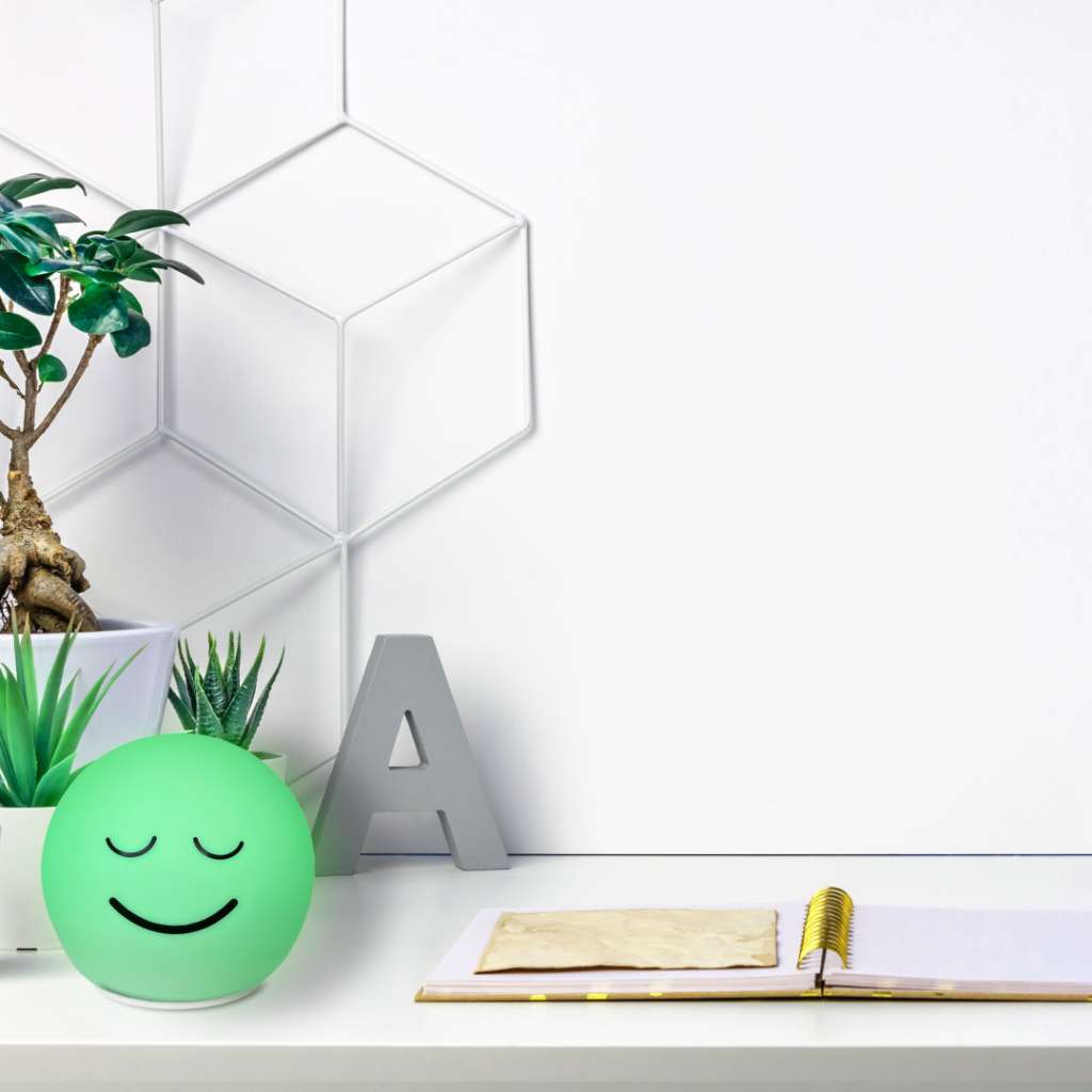 Green smiling Breathing Ball lamp on a desk guiding calm deep-breathing HRV biofeedback relaxation